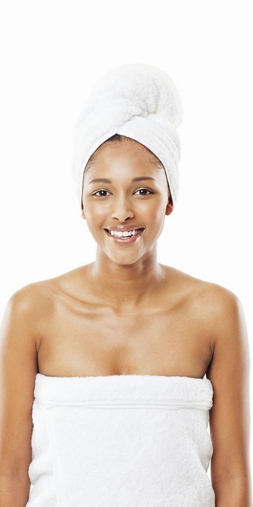 Young woman poses while wearing bath towels. Square shot. Isolated on white.